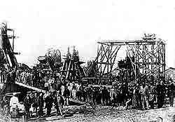 A construction site: engineers and workers posing beside their dredgers